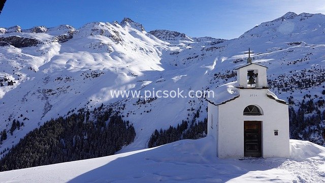 White Chapel Amid Winter Snowy Mountains, Graubünden, Switzerland