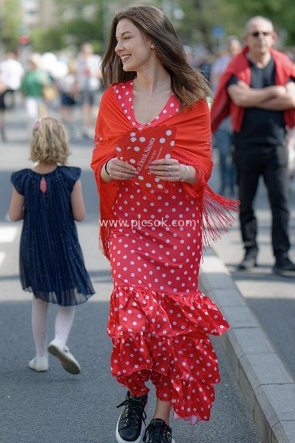 Joyful Girl Strolling on the Street – Fashionable Outfit, Distributing Leaflets